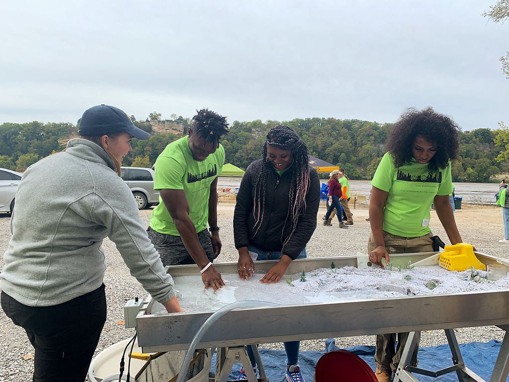 Diamond Dunn, far right, along with other YouthBuild members, participated in the stream table demonstration to simulate the flow of water channels at the Stewardship